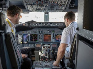 Photos of two pilots seated in a cockpit